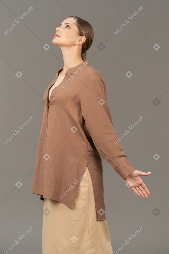Jeune femme debout et écartant les bras