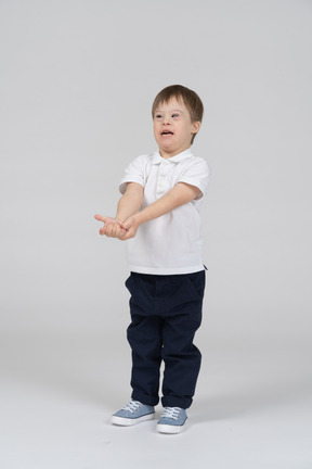 Front view of a little boy holding out his hands