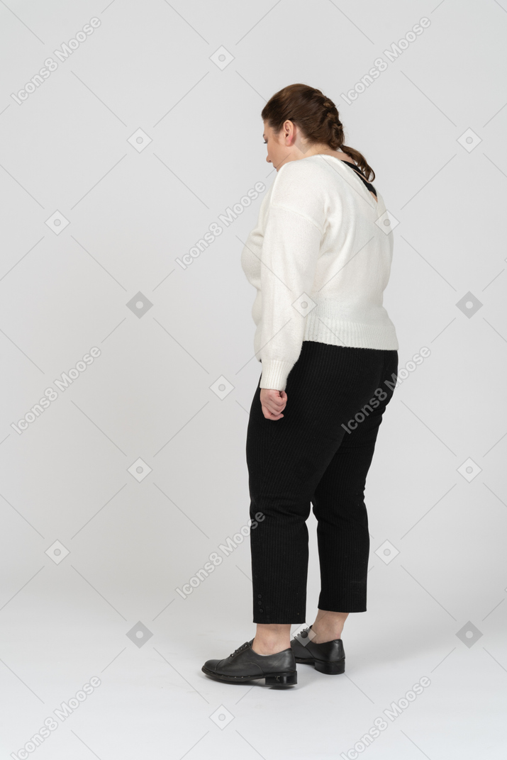 Plus size woman in white sweater standing