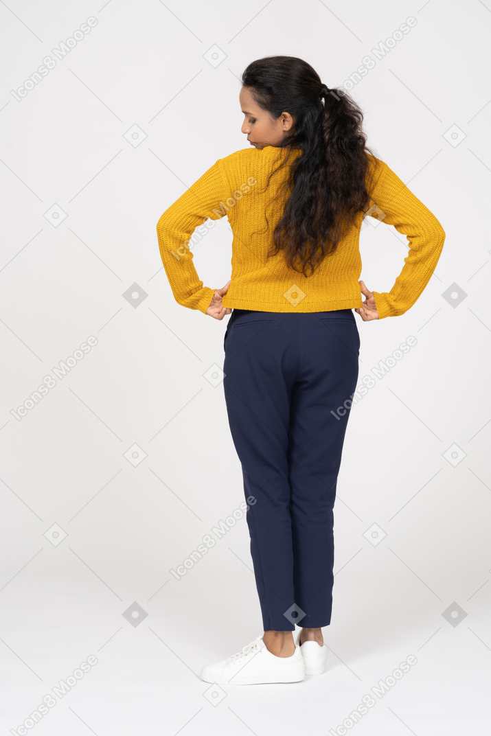 Back view of a girl in casual clothes checking if her shirt is clean