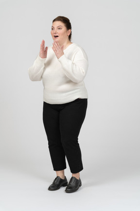 Surprised plump woman in casual clothes standing in profile