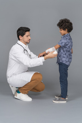 Médico e menino com braço quebrado