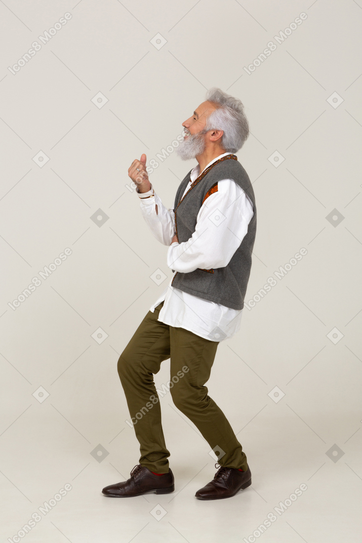 Вид сбоку человека, стоящего с согнутыми коленями и сжатым кулаком
