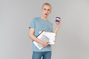 Mignon jeune homme androgyne vêtu d'un t-shirt bleu clair et d'un jean bleu sur le chemin de l'université