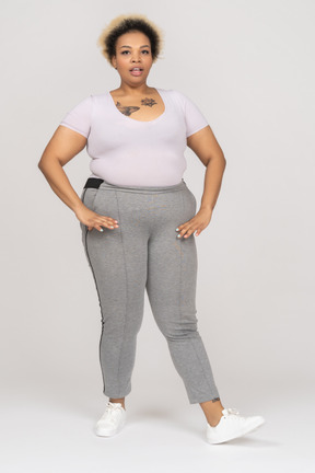 Mujer afro regordeta posando en mallas deportivas y camiseta blanca