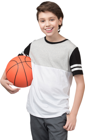 Boy holding basketball ball and smiling