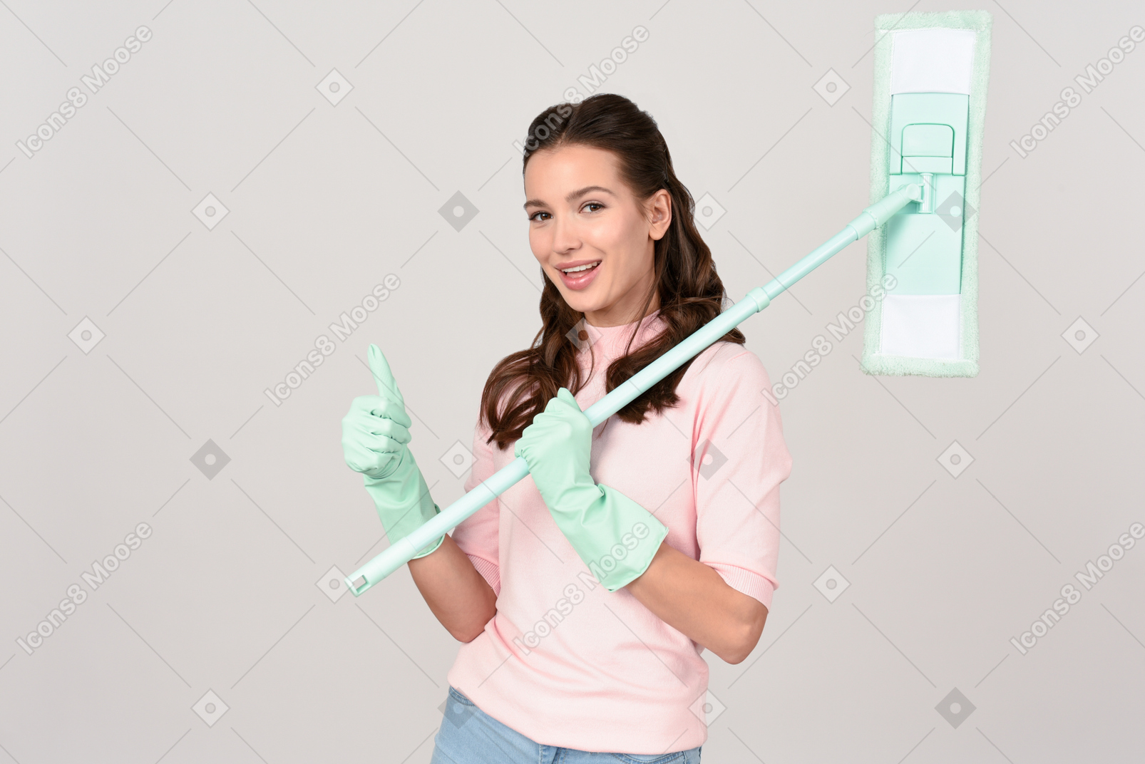 Attractive young woman with a mop showing thumbs up
