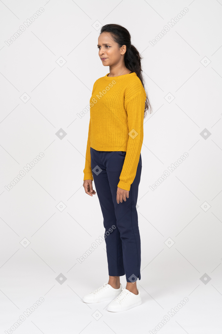 Confused young woman in casual clothes standing in profile