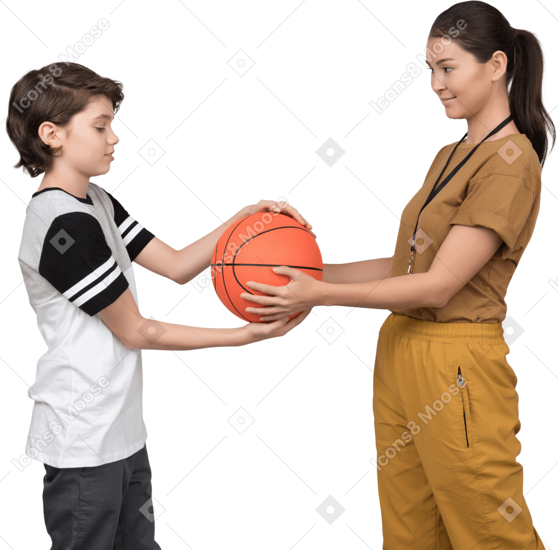 Pe女教師と生徒がバスケットボールを保持