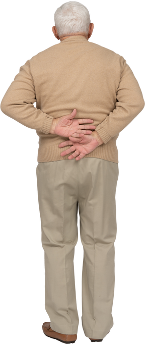 Rear view of an old man in casual clothes standing with hands on back