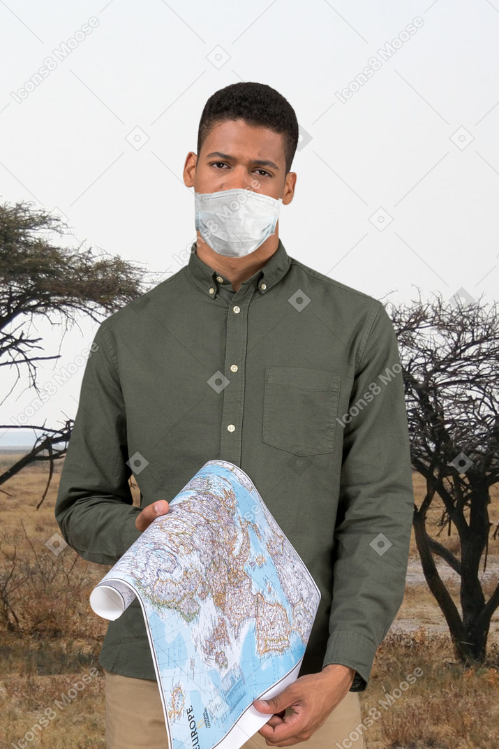 A man in a green shirt is holding a map