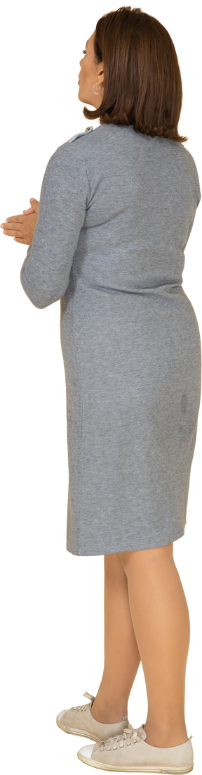 Vista posteriore di una donna in abito grigio in posa