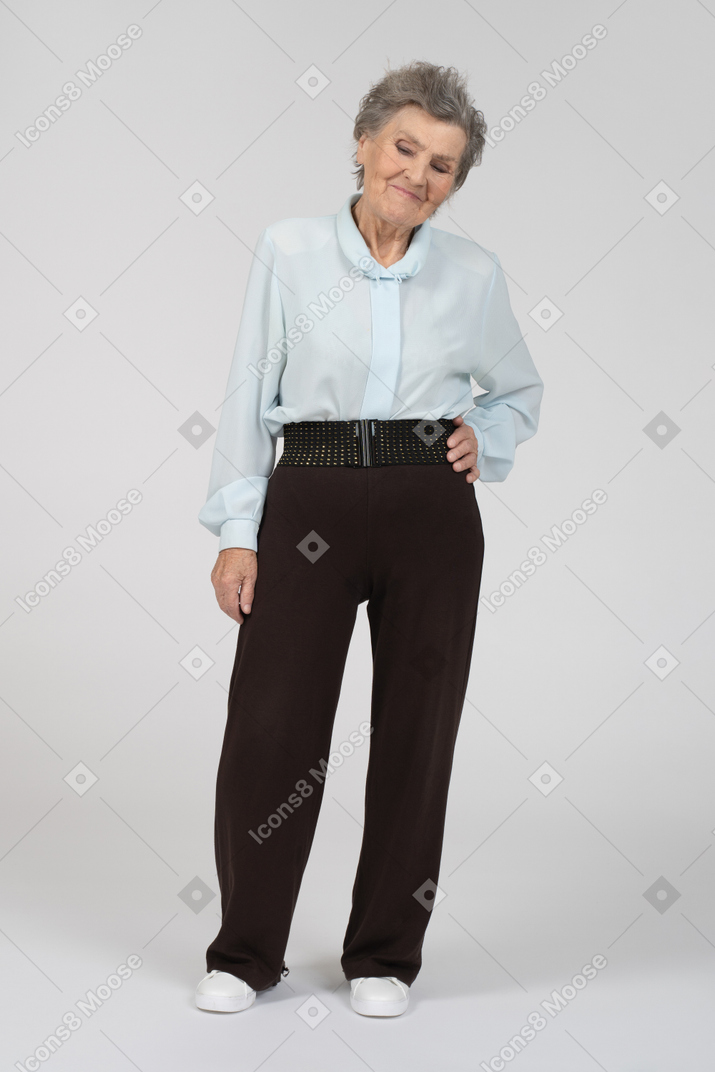 一位老妇人的正面图，手放在臀部微笑