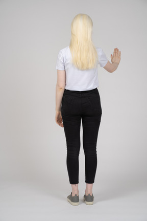 Back view of a young girl showing stop hand signal