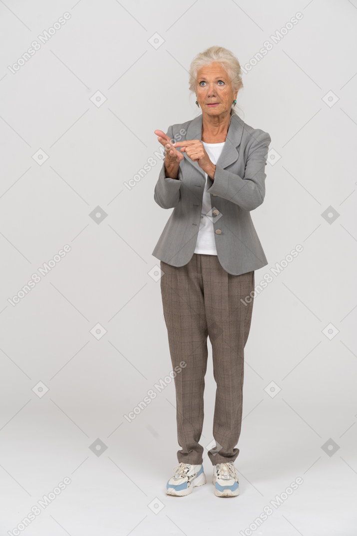 Vista frontale di una vecchia signora in giacca e cravatta che spiega qualcosa