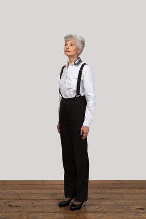 Three-quarters view of a hopeful old female dressed in office clothes