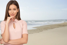 A woman standing on a beach next to the ocean