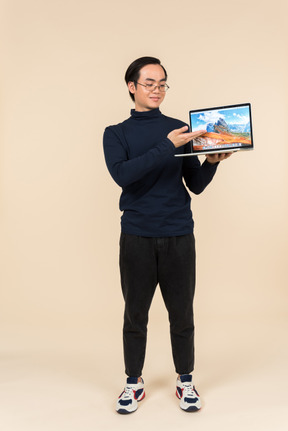 Young asian man presenting a laptop