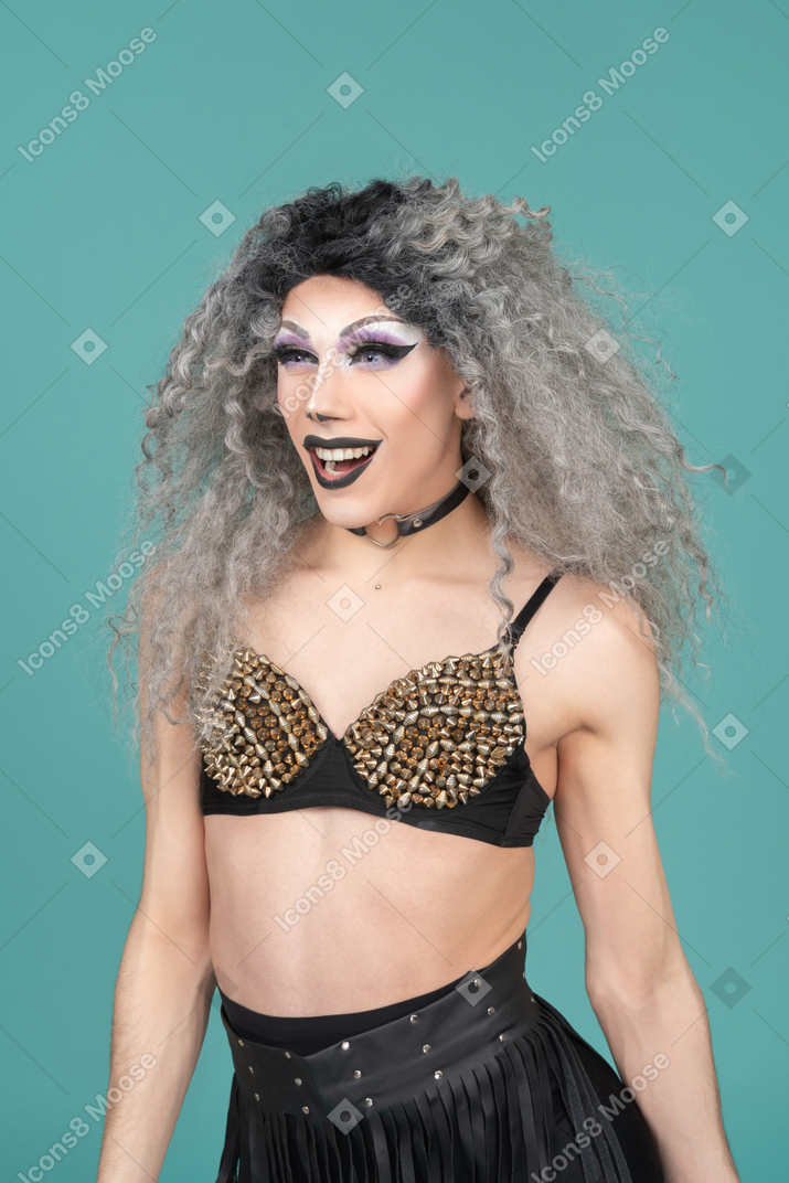 Retrato de una drag queen en sujetador tachonado sonriendo emocionada