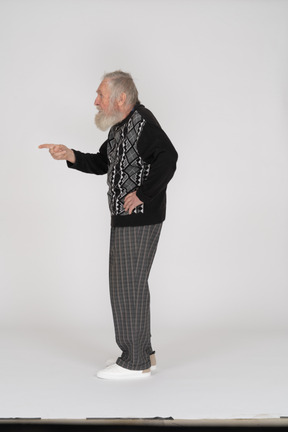 Side view of an old man pointing to the left