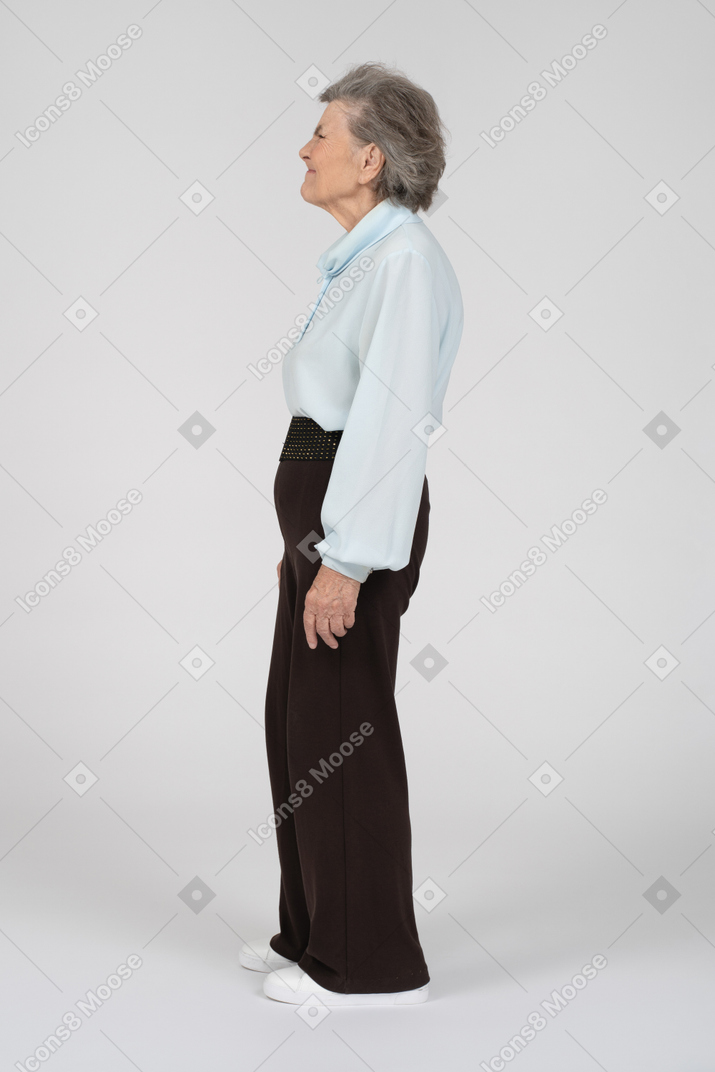 Side view of an old woman wrinkling her nose appallingly