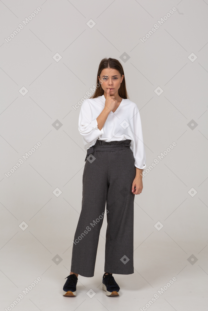 Front view of a young lady in office clothing biting her finger