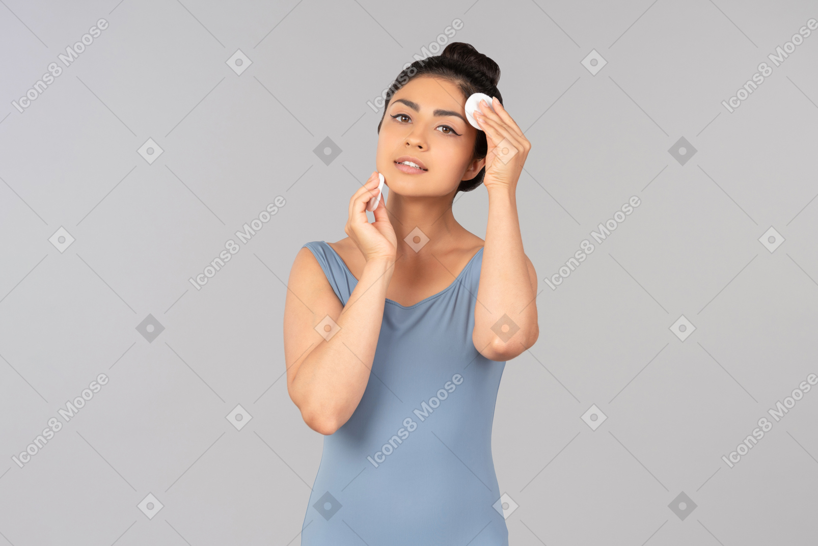 綿パッドで顔を掃除する若いインド人女性