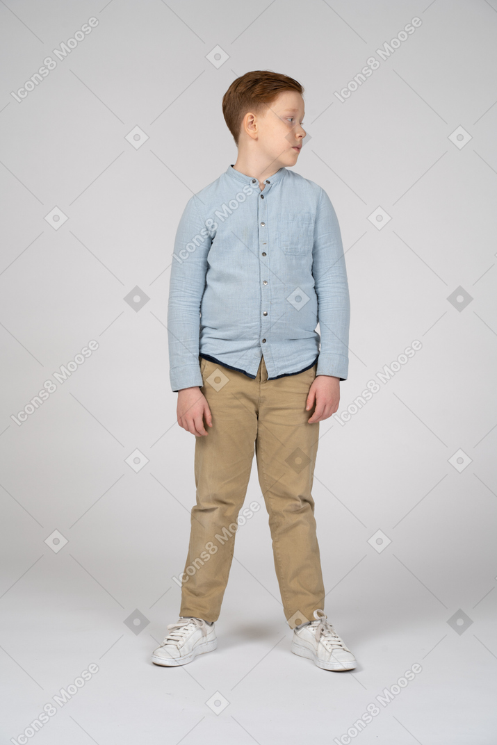 Front view of a cute boy in casual clothes looking aside