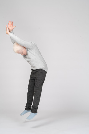 Three-quarter view of a young boy jumping