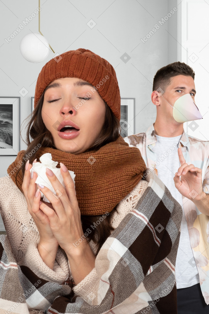 Woman sneezing and man looking scared