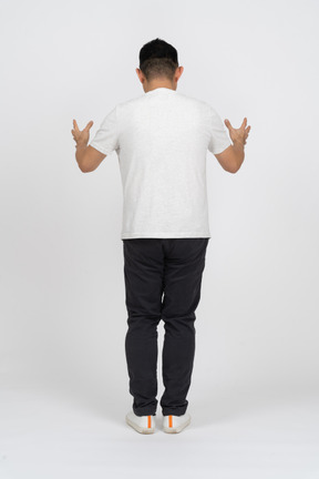 Vista posteriore di un uomo in abiti casual che mostra le dimensioni di qualcosa