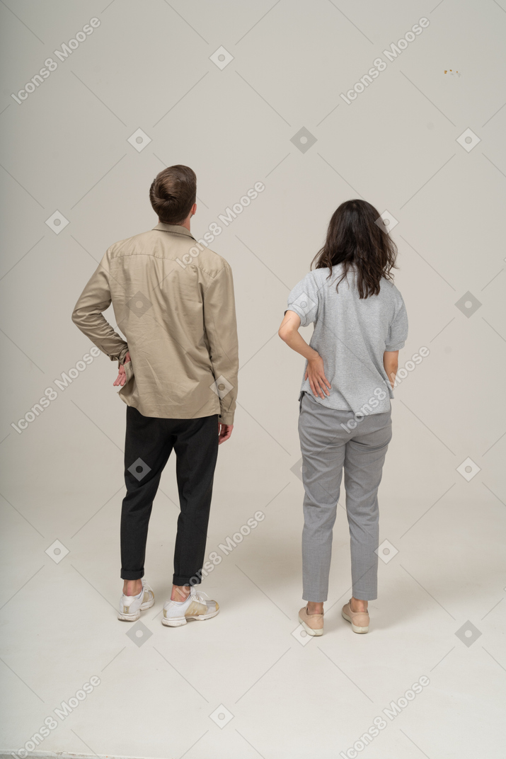 Вид сзади на молодого мужчину и женщину, отводящих взгляд