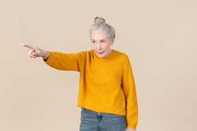 Elegant older woman pointing at something