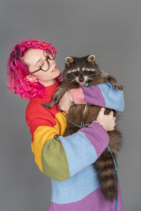 Young woman holding a racoon