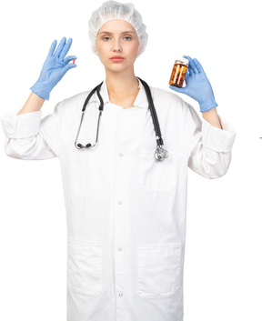 Vista frontal de una joven doctora eligiendo entre pastillas