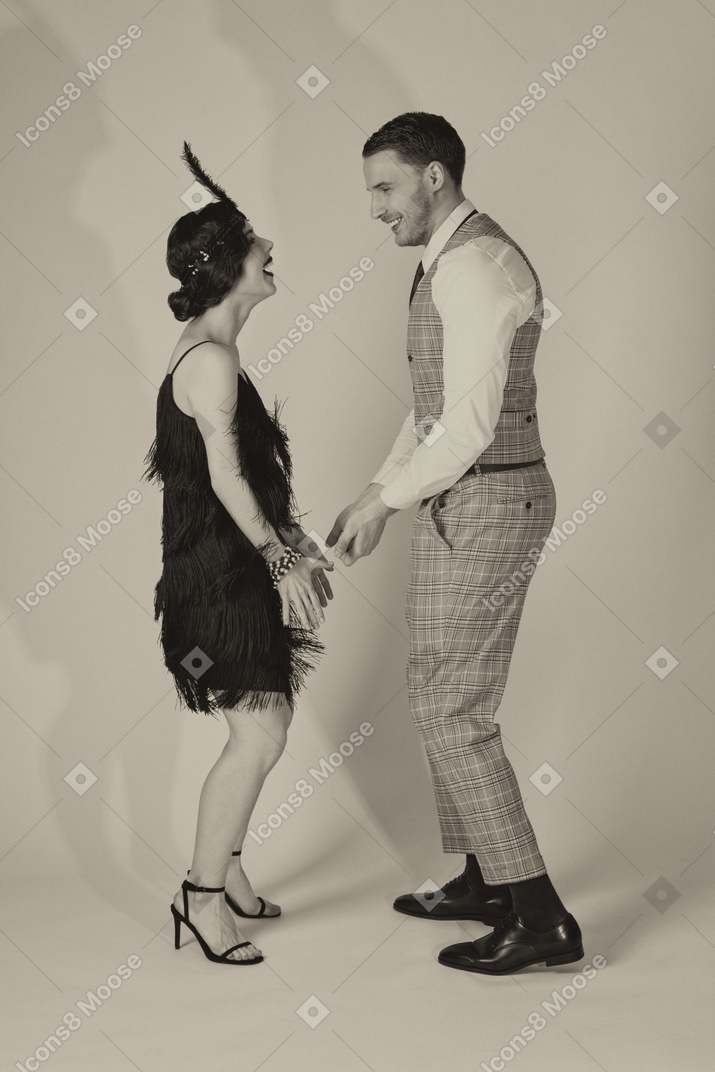 Jovem casal animado executando dança charleston