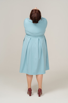 Vista posteriore di una donna in abito blu che guarda in alto