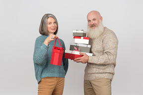 Homme âgé, offrant des cadeaux à une femme élégante et mature