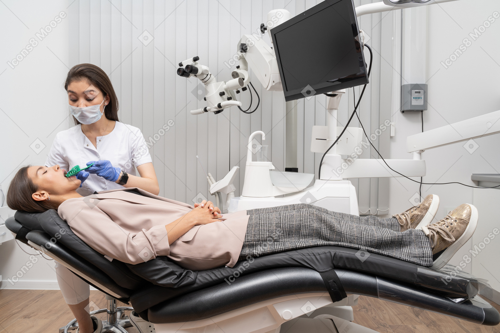 Toute la longueur d'une femme dentiste faisant un dossier dentaire à sa patiente dans une armoire d'hôpital