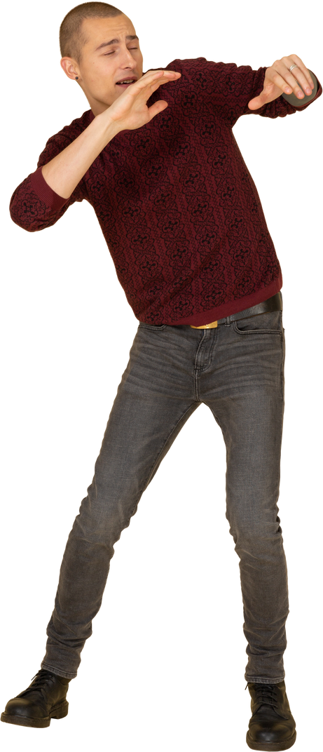 Front view of a scared young in red pullover raising his hands