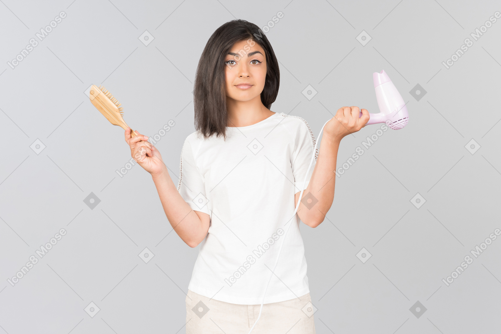 Young indian woman with messy hair holding hairbrush and dryer
