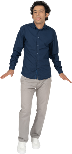 Front view of a man in casual clothes showing tongue and gesturing