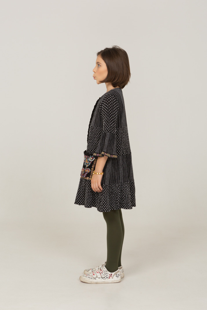 Side View Of A Pouting Little Girl In Dress Looking Aside Photo