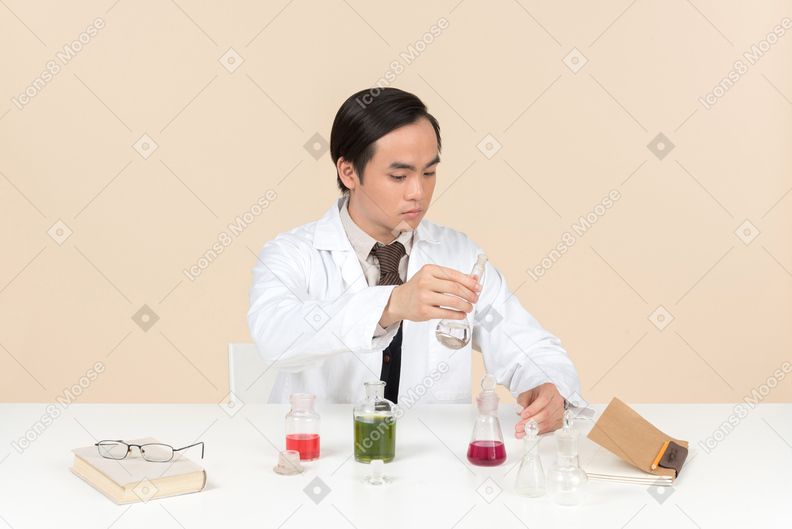 Un científico asiático en una bata blanca trabajando en un experimento químico