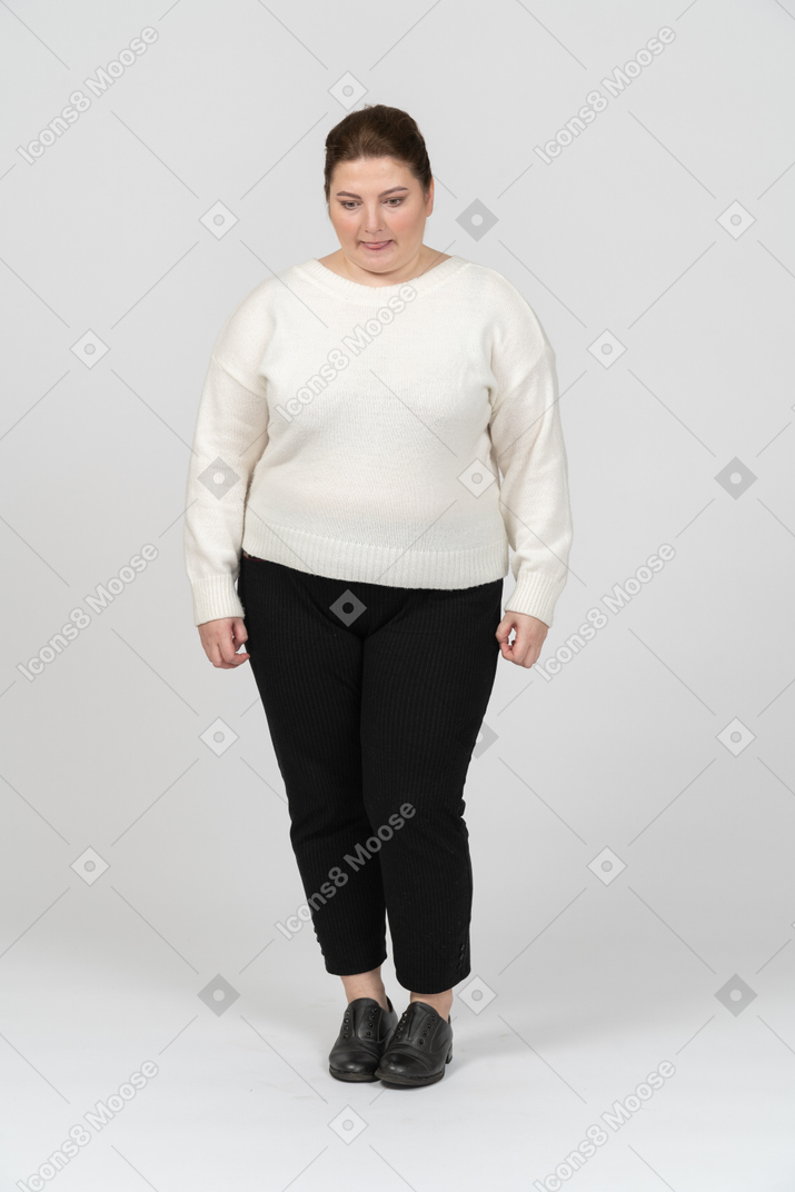 Plump woman in white sweater looking down