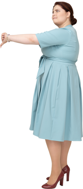 Vista lateral de uma mulher de vestido azul mostrando o polegar para baixo