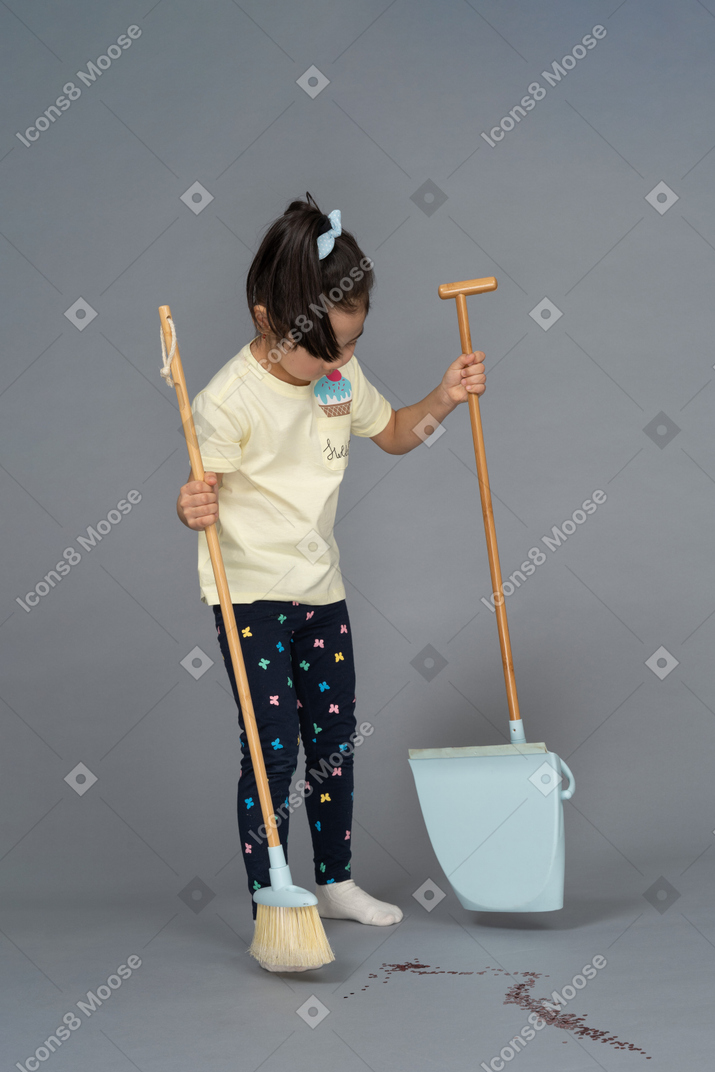 Little girl getting ready to sweep the floor