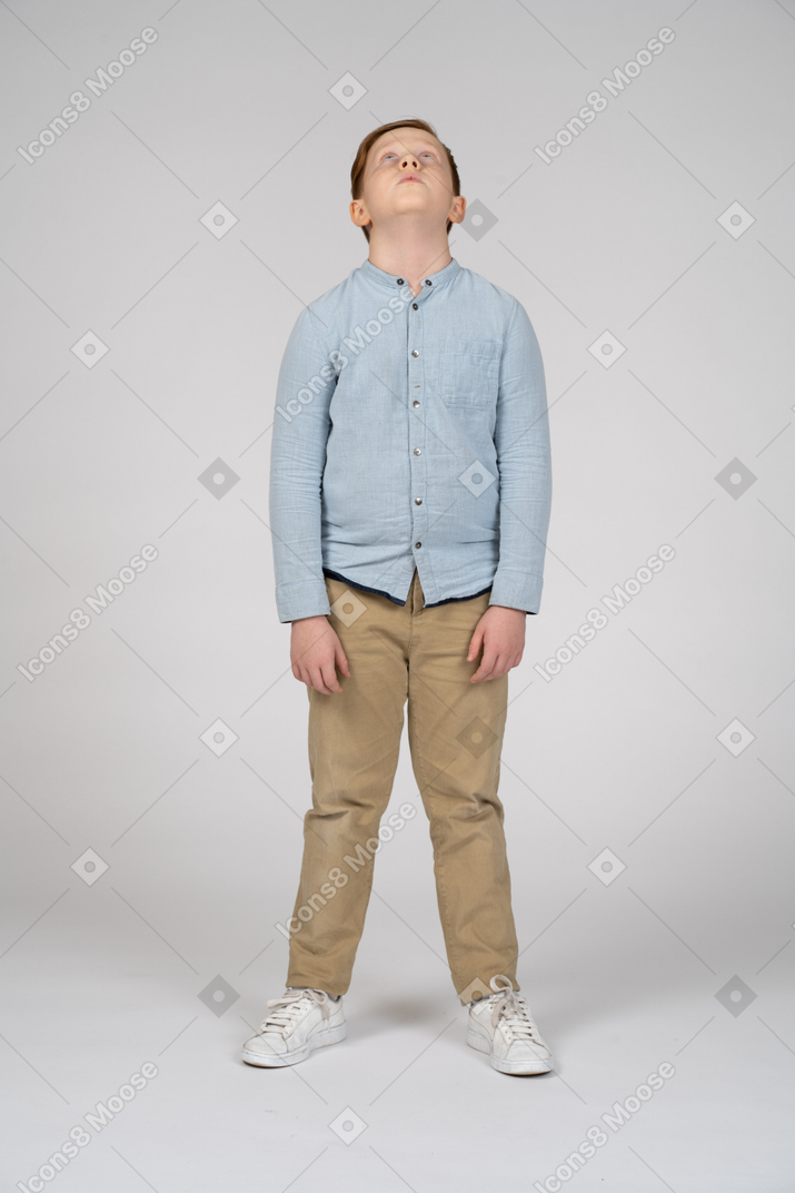 Front view of a boy in casual clothes looking up