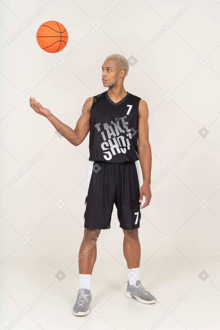ボールを投げる若い男性のバスケットボール選手の正面図