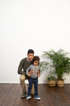 Good looking young man playing with a boy